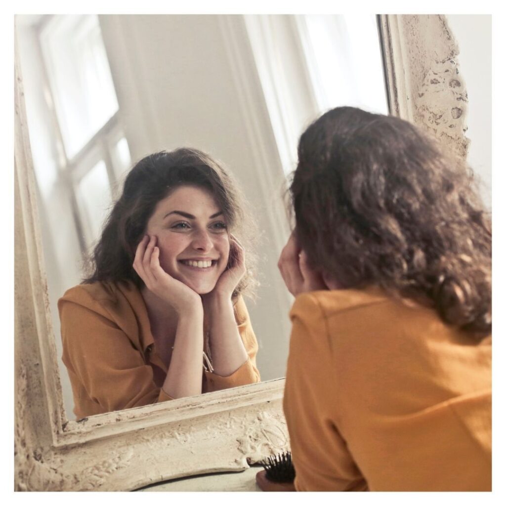 IPL therapy is a non-invasive procedure, brunette woman smiling at herself in mirror