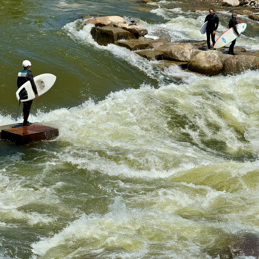 People waiting to jump in and surf white water of river. Skincare for Active Lifestyles in Colorado